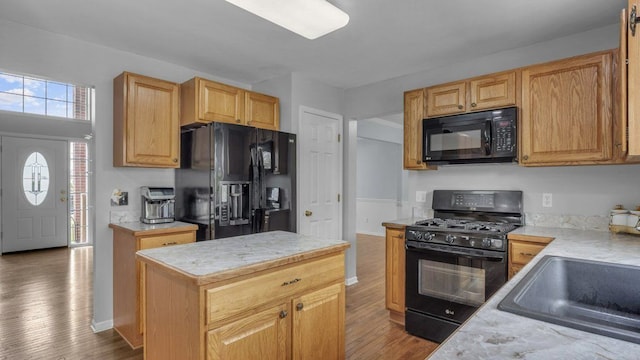 56501 Winding Creek Dr, Macomb, MI 48042 - kitchen with black appliances, wood finished floors, light countertops, and a center island
