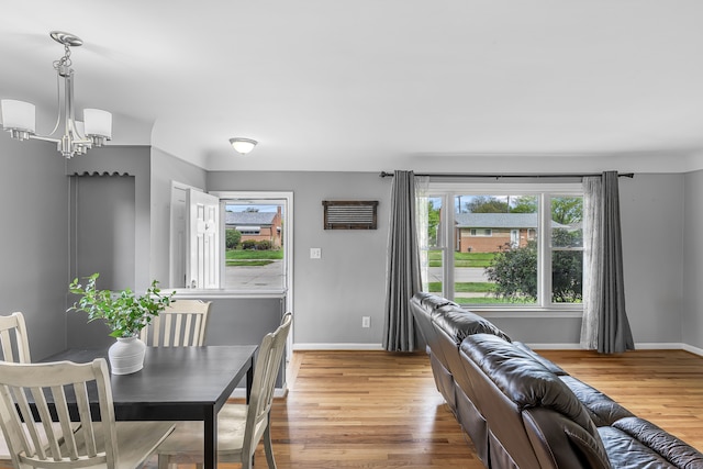 dining room featuring a chandelier, baseboards, and light wood-style floors