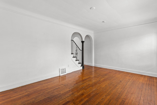1946 Ewald Cir, Detroit, MI 48238 - spare room with arched walkways, stairs, hardwood / wood-style flooring, and baseboards