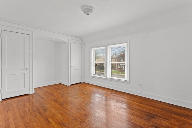 1946 Ewald Cir, Detroit, MI 48238 - unfurnished bedroom with hardwood / wood-style floors, baseboards, and arched walkways