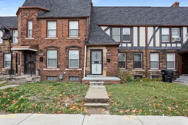 1946 Ewald Cir, Detroit, MI 48238 - townhome / multi-family property featuring a front lawn, cooling unit, roof with shingles, and brick siding