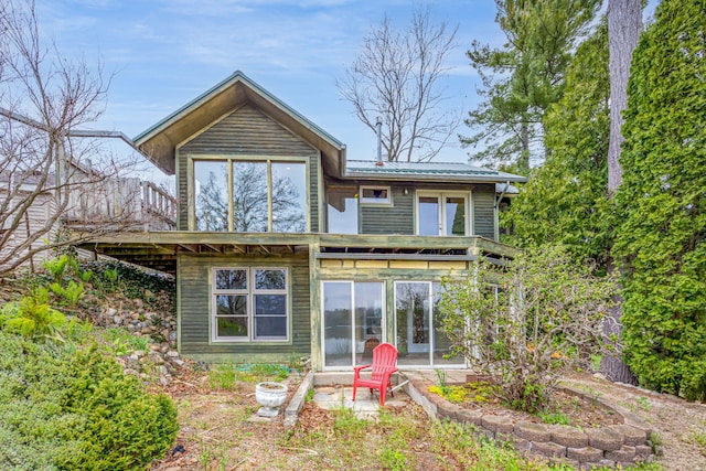 back of house with a sunroom and metal roof