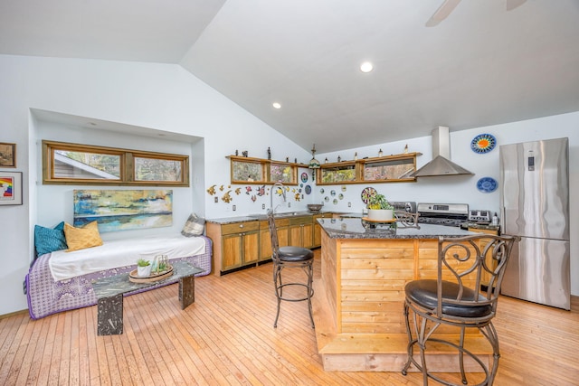 kitchen with wall chimney range hood, stainless steel appliances, open shelves, light wood finished floors, and lofted ceiling