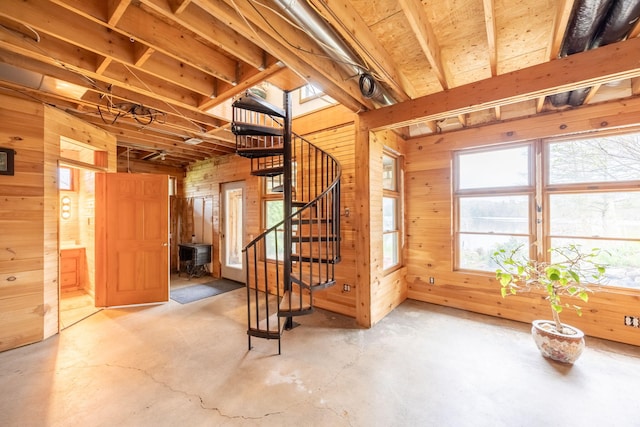 below grade area featuring wooden walls, stairs, and a wood stove