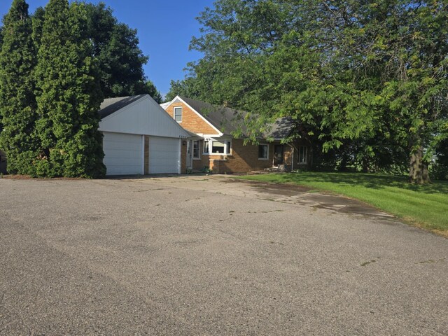 4618 New Holland St, Hudsonville, MI 49426 - view of front facade featuring a garage, asphalt driveway, a front yard, and brick siding