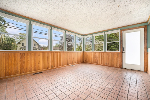 unfurnished sunroom featuring wood walls and baseboards