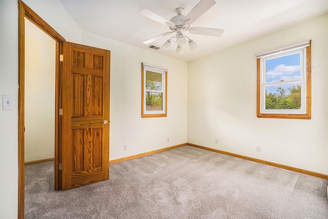 spare room featuring carpet flooring, baseboards, and ceiling fan