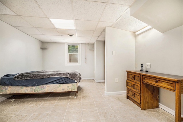 bedroom featuring a paneled ceiling, baseboards, and light tile patterned floors