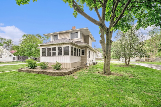 view of home's exterior featuring a chimney, a yard, a shingled roof, and cooling unit