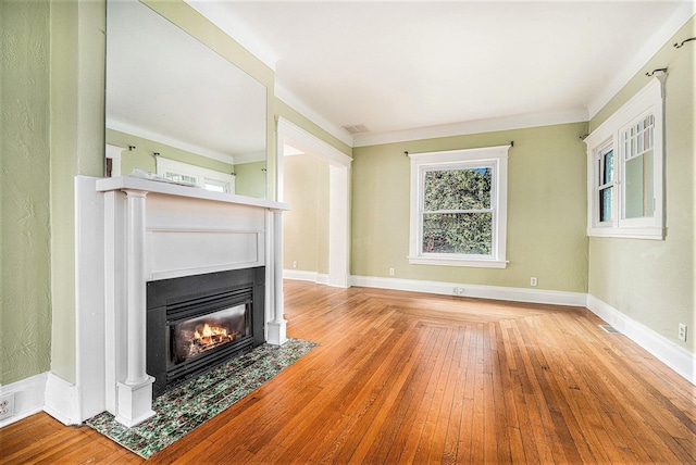 unfurnished living room featuring a fireplace with flush hearth, wood-type flooring, and crown molding