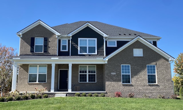 craftsman-style house with a porch, brick siding, and a front lawn