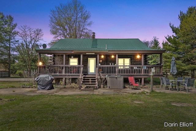 5359 Huck Dr, Sheridan, MI 48884 - back of house at dusk featuring a chimney, a yard, and log siding