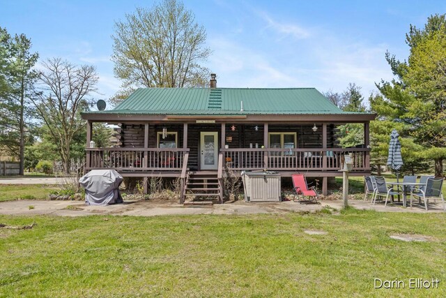 5359 Huck Dr, Sheridan, MI 48884 - view of front of home featuring log exterior, a front lawn, a chimney, and metal roof