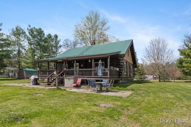 5359 Huck Dr, Sheridan, MI 48884 - log cabin with a patio area, log siding, a front yard, metal roof, and a wooden deck