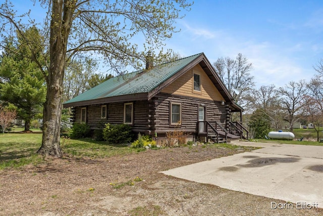 5359 Huck Dr, Sheridan, MI 48884 - view of home's exterior featuring log siding and metal roof