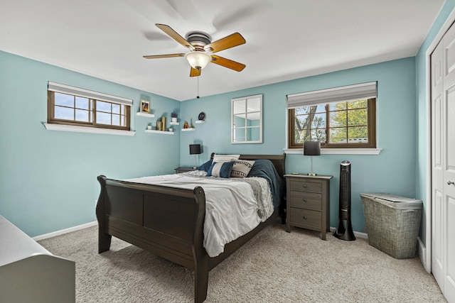 carpeted bedroom featuring multiple windows, baseboards, a ceiling fan, and a closet