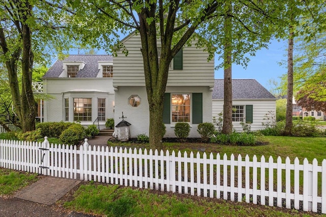 view of front of house featuring roof with shingles and a fenced front yard