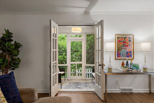 entryway with french doors, wood finished floors, baseboards, and ornamental molding