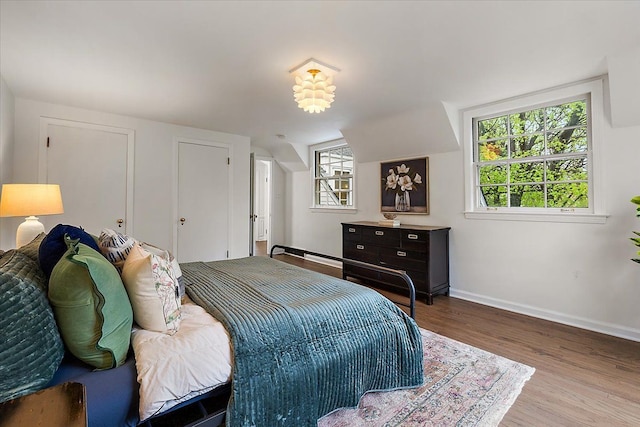 bedroom with wood finished floors and baseboards