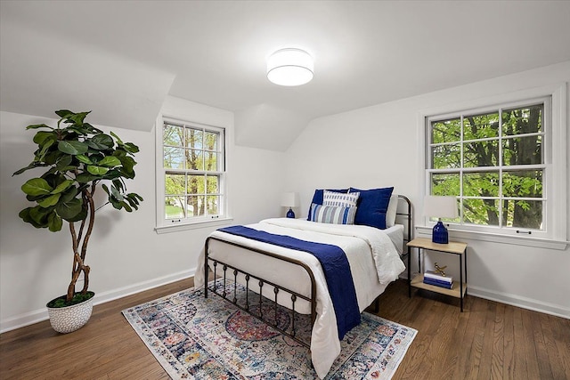 bedroom featuring baseboards, lofted ceiling, and wood finished floors