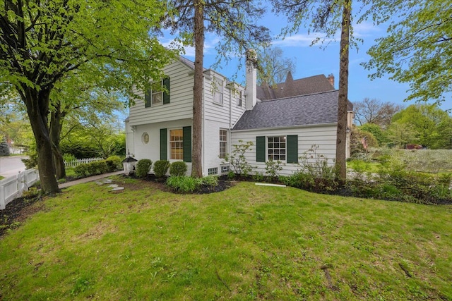 view of front of property featuring a chimney and a shingled roof
