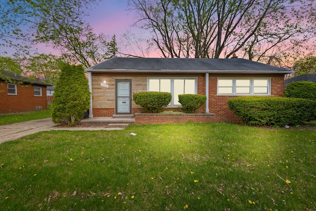 view of front facade featuring a yard and brick siding