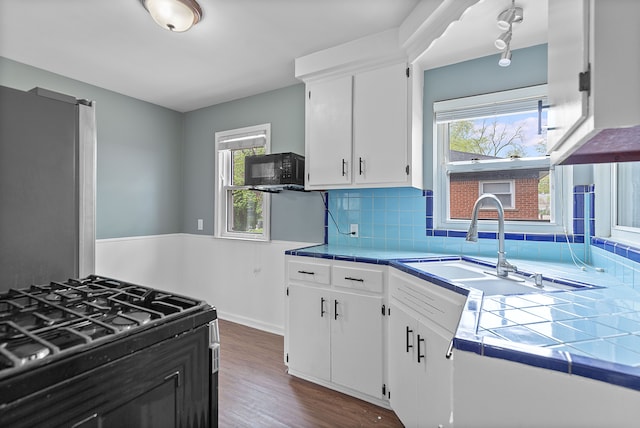 kitchen with tile countertops, black appliances, white cabinets, and dark wood finished floors