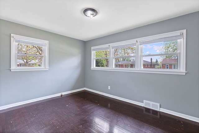 unfurnished room with baseboards and wood finished floors