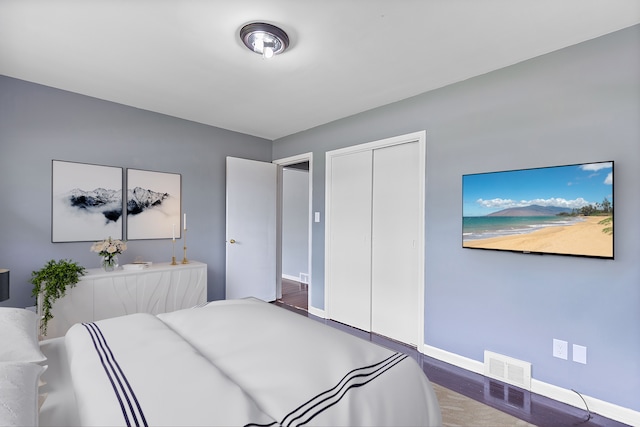 bedroom with baseboards, a closet, and wood finished floors
