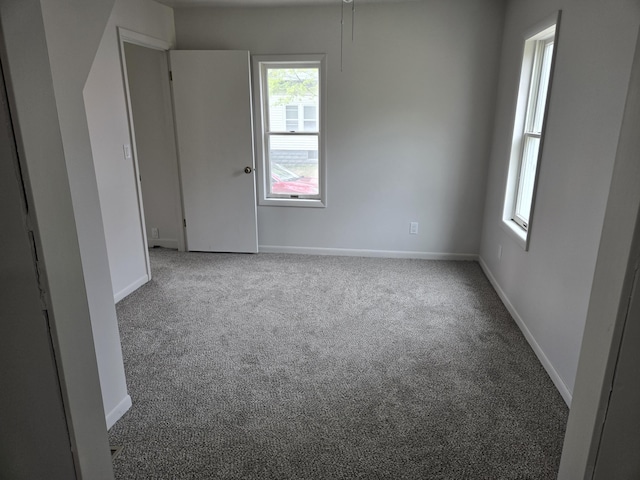 unfurnished room with carpet flooring, healthy amount of natural light, and baseboards