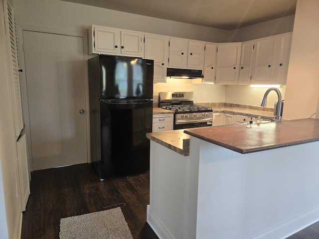 kitchen featuring freestanding refrigerator, stainless steel range with gas stovetop, a sink, under cabinet range hood, and dark wood finished floors