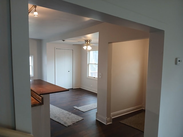 interior space with dark wood-style flooring, baseboards, and ceiling fan