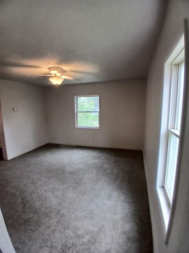 carpeted empty room featuring a ceiling fan