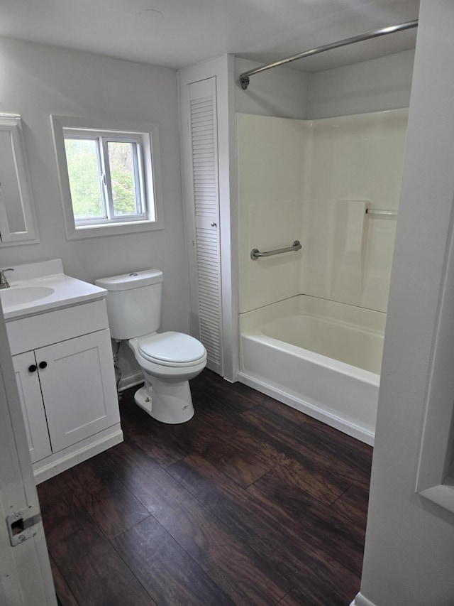 full bathroom featuring toilet, vanity, wood finished floors, tub / shower combination, and a closet