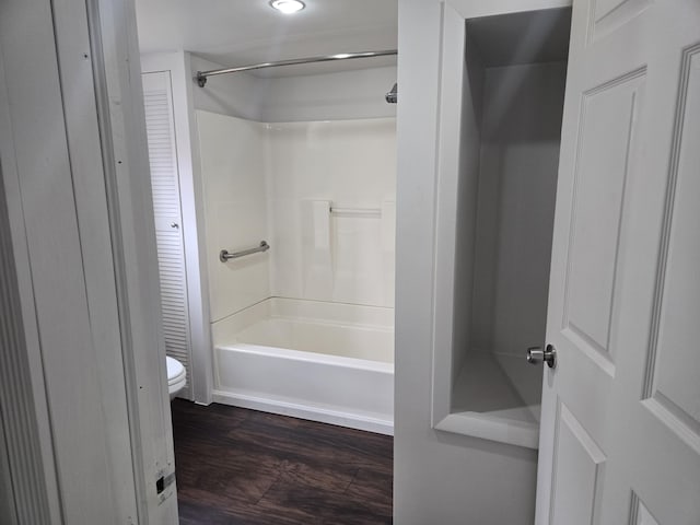bathroom with wood finished floors, toilet, and bathtub / shower combination