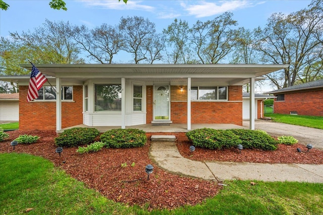 view of front of house featuring brick siding, covered porch, and asphalt driveway