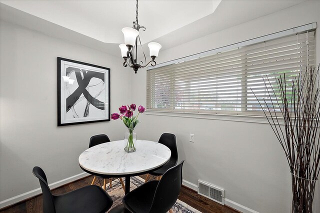 dining room featuring a chandelier, baseboards, and wood finished floors