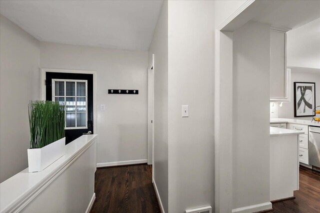 corridor with dark wood-style floors and baseboards