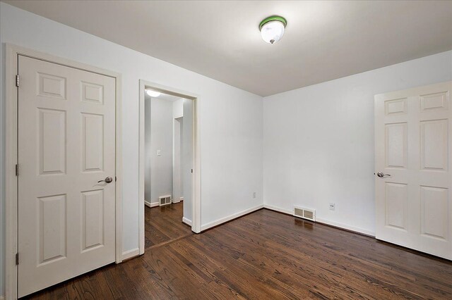 unfurnished bedroom featuring dark wood finished floors and baseboards