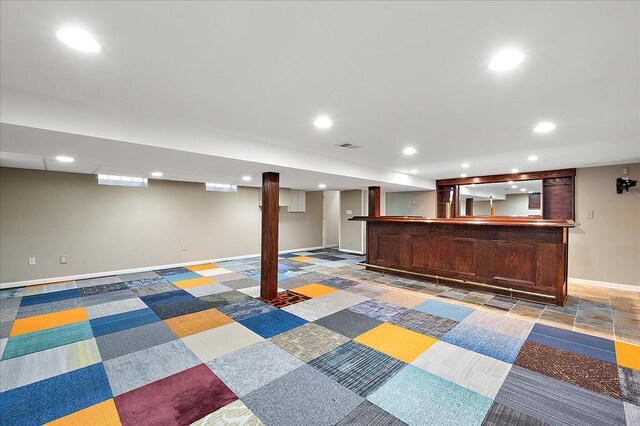 finished basement featuring bar with sink, recessed lighting, and baseboards