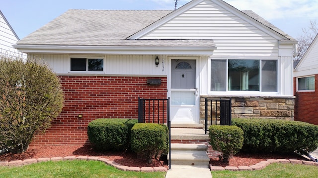 23162 Saxony Ave, Eastpointe, MI 48021 - bungalow-style house with roof with shingles, brick siding, and stone siding
