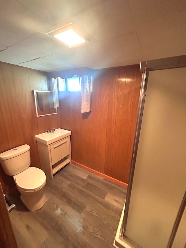 23162 Saxony Ave, Eastpointe, MI 48021 - bathroom featuring wood finished floors, a stall shower, toilet, vanity, and wooden walls