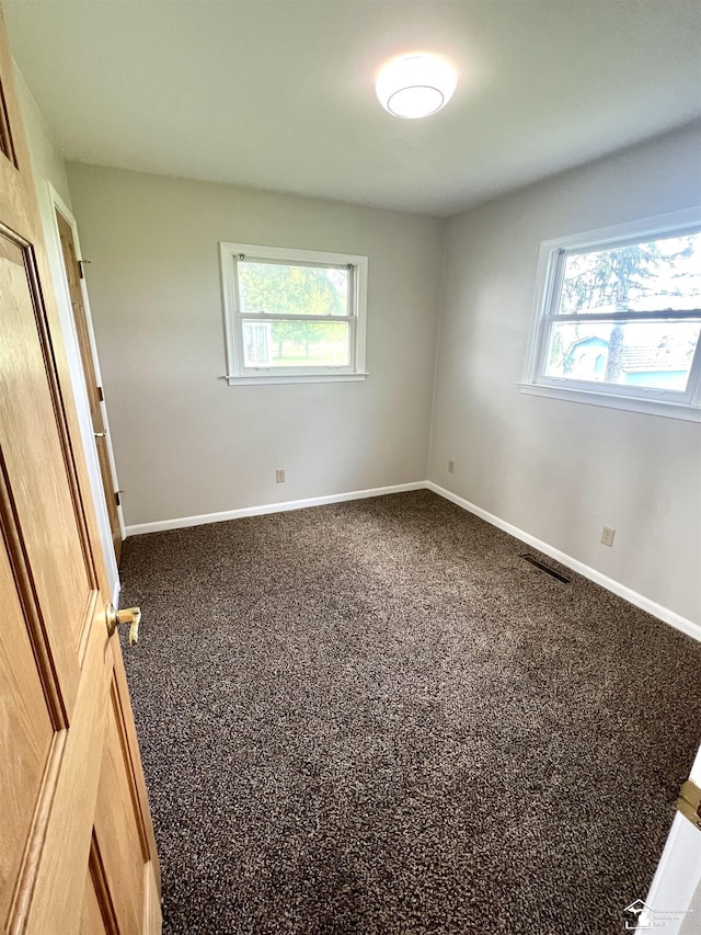 unfurnished bedroom featuring multiple windows and baseboards