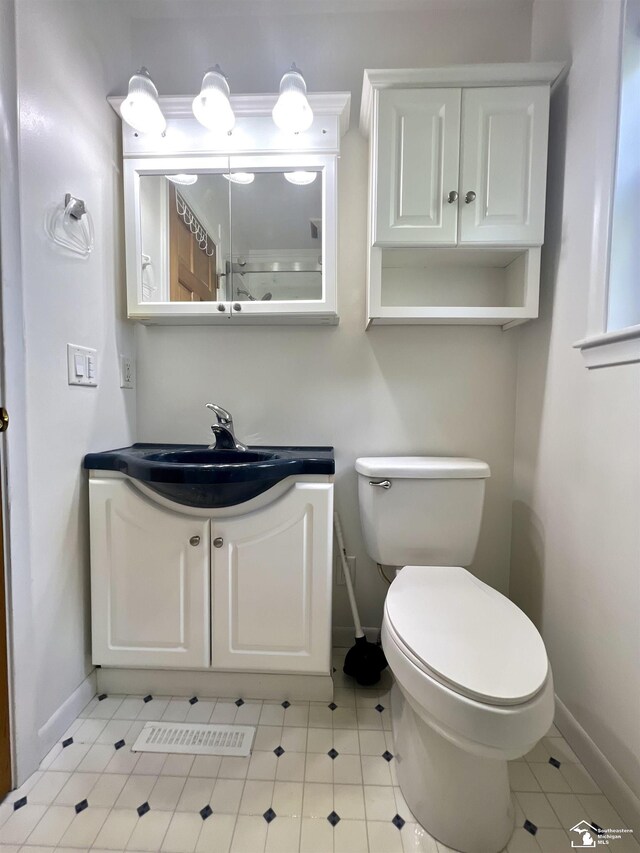 bathroom featuring baseboards, toilet, and vanity