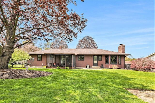 rear view of property featuring a chimney and a sunroom