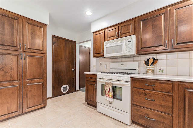 kitchen with white appliances, backsplash, light countertops, light tile patterned flooring, and recessed lighting