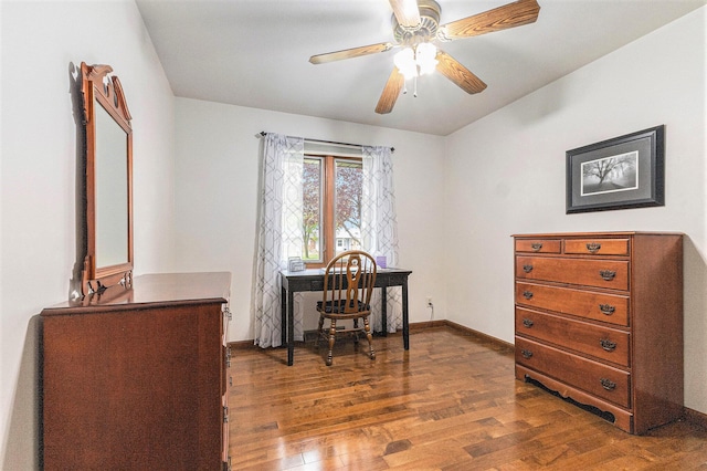 office featuring dark wood-style floors, a ceiling fan, and baseboards