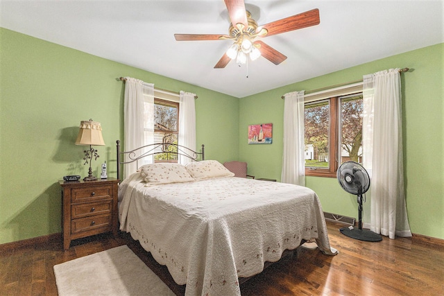 bedroom featuring baseboards, wood finished floors, and ceiling fan