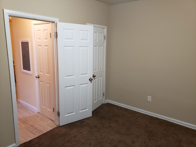 unfurnished bedroom featuring electric panel, carpet flooring, and baseboards