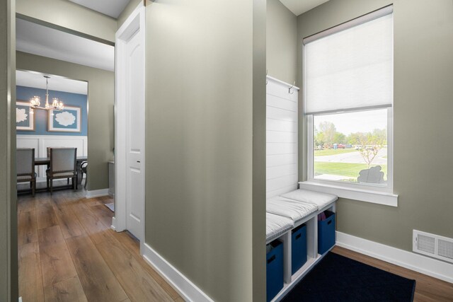 hallway with a chandelier, wood finished floors, and baseboards